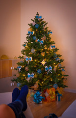 Christmas. Christmas tree, decorated gift box, woman legs