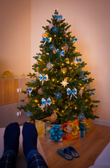 Christmas. Christmas tree, decorated gift box, woman legs