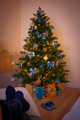 Christmas. Christmas tree, decorated gift box, woman legs
