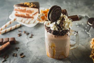 Chocolate milkshake with dripping sauce, cream, cocoa cookies