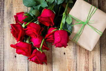 Mother day background or Valentines Day, wedding day. Beautiful blooming Red roses and present on wooden board. Top view flat lay background. Copy space.