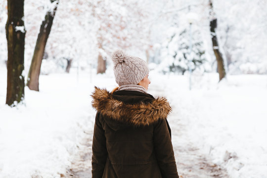 Young woman walking in the park on a snowy day