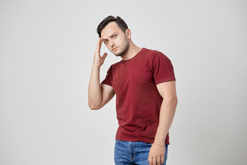 Thoughtful man in the burgundy t-shirt