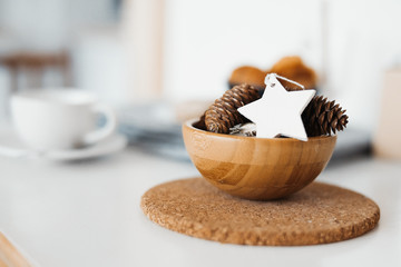 Close up of bowl with pine cones and christmas tree toy.