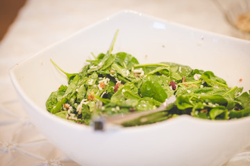 spinach salad in white bowl
