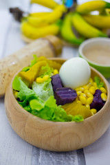 Fresh fruit and fresh vegetable salad with cream salad in wooden bowl