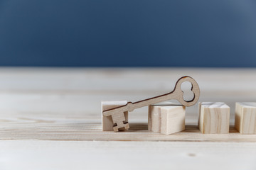 Real estate concept. Small toy wooden house with keys