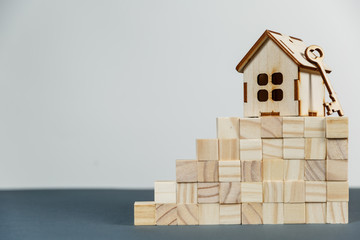 Real estate concept. Small toy wooden house with keys