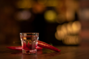 a glass of vodka and chilli pepers