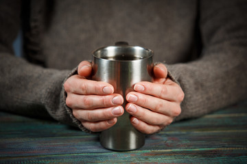 Woman holds a cup of hot tea. Cozy morning at home.