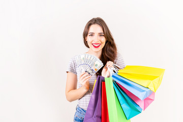 Spring summer season sale concept. Attractive young woman with long brunette hair, wearing slim fit casual shirt, holding many different blank shopping bags over white background. Copy space, close up