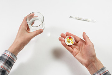 man hand with water on the background of pills