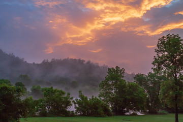 Smoky mountain sunrise with mist in the clouds and golden light in the clouds