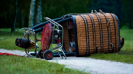 Gondola with envelope lying on grass, preparation before start, hot air balloon