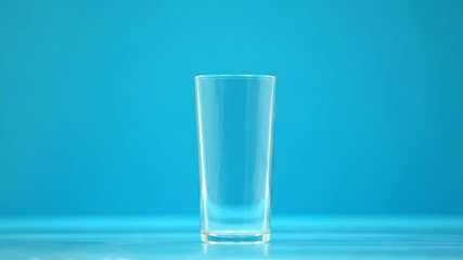 Empty drinking cup, glass for milk and water on blue background, zero calorie