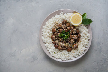 Juicy diet meatballs with rice on a gray table