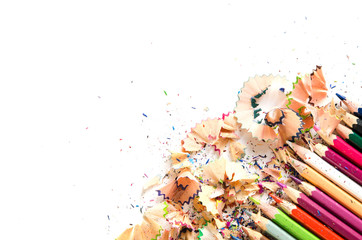 Drawing tools background. Lot of colorful pencils frame with sawdust and shavings on white, copy space, flat lay