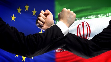EU vs Iran confrontation, countries disagreement, fists on flag background