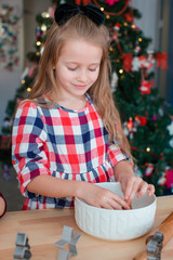 Adorable little girl baking Christmas gingerbread cookies