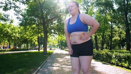 Obese girl jogging, suffocating, feels belly pain after tiresome workouts