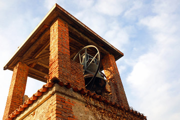 ancient medieval brick bell tower with bronze bell