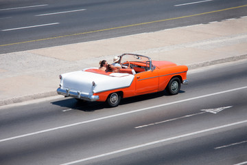Turistas a bordo de coche clásico americano descapotable de los años 50 circulando por el...