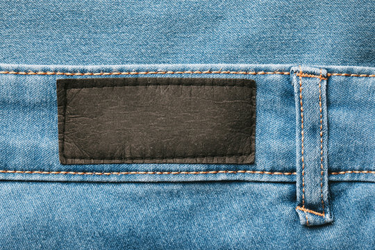 Empty copy space black label patch on blue jeans denim background.