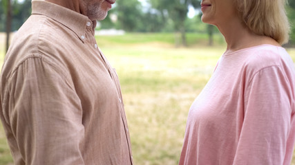 Elderly man and woman looking each other, romantic meeting in countryside, date