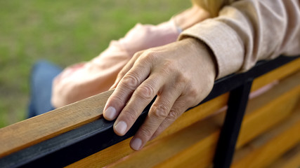 Wrinkled male hand hugging woman during outside date, spouse care, attention