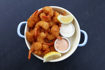 Portion of breaded shrimps with dipping sauces