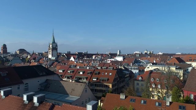 Aerial shot, with pan to the right over rooftops in Freiburg, Germany. 