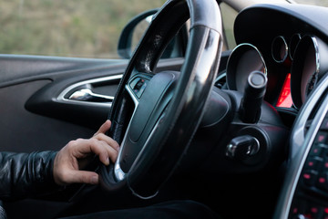 Male driver holding steering wheel while driving