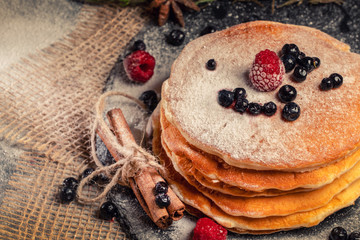 Delicious pancakes with fresh fruit on dark wooden background