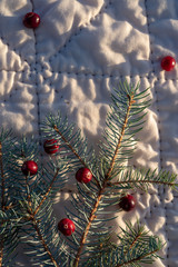 hand-stitched white quilt with Blue Spruce branch and raw red cranberries holiday Christmas background