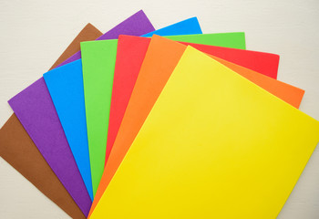 Colorful eva foam scattered on white wooden surface