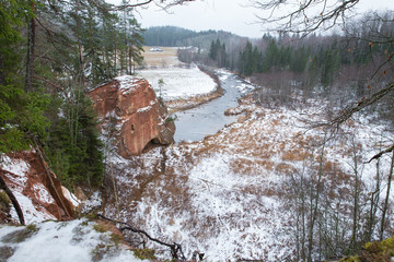 Red cliffs and river in winter. Snow and rocks, travel photo 2018