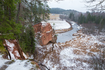 Red cliffs and river in winter. Snow and rocks, travel photo 2018
