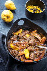 Traditional Iranian khoresh beh stew with chunks of lamb, quinces and saffron rice as top view in a modern design cast-iron roasting dish