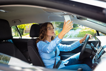 Fototapeta na wymiar Young businesswoman taking selfie while driving a car