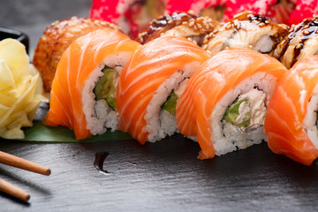 Sushi rolls closeup. Japanese food in restaurant. Roll with salmon, eel, vegetables and flying fish...