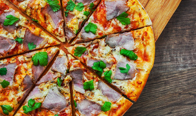 Pizza with Mozzarella cheese, ham, pepper, meat, Tomato sauce, Spices and Fresh Basil. Italian...