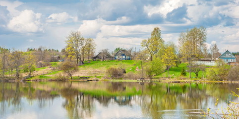 Spring landscape with a village by the river