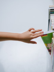 Girl chose a book from bookshelf