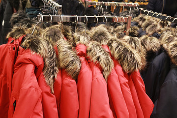 red jackets with a fake fur collar hanging in a row © schapinskaja
