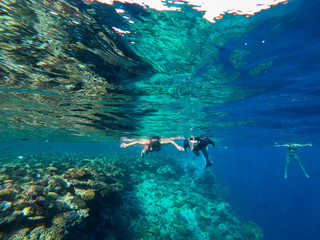 red sea people swim under water
