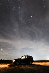 Obraz na płótnie Canvas Ein Geländewagen unter einem Sternenhimmel, Milchstraße