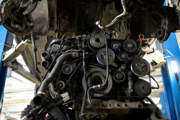 Mechanic hand checking and fixing a broken car in car service garage