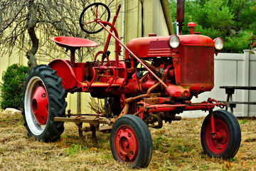 Obraz premium A red light duty farm tractor sits idle