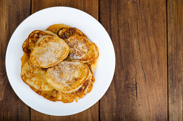 White plate with pancakes on wooden table