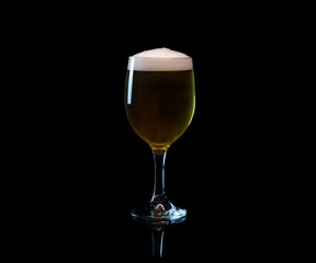 Beer in wine glass isolated on black with reflection
